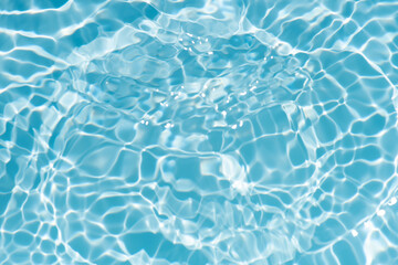 Obraz premium Bluewater waves on the surface ripples blurred. Defocus blurred transparent blue colored clear calm water surface texture with splash and bubbles. Water waves with shining pattern texture background.