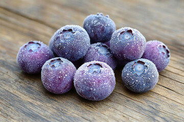 Frozen Blueberries with Frost on Wooden Surface