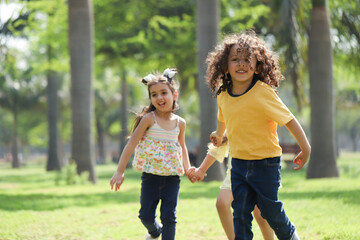 Fototapeta premium Happy Kids Holding Hands While Running In Outdoor