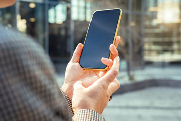 Mockup blank touch screen mobile phone in hands of businesswoman.