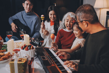 Multi-Generation Family Celebrate Christmas At Home Wearing Santa Hats And Antlers Opening Presents