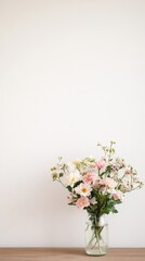 Pink and white flowers arranged in a glass vase on a wooden table against a minimalist white wall, creating a serene atmosphere ideal for romantic celebrations
