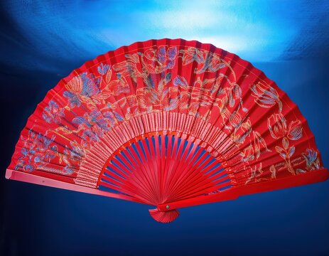 A red fan with intricate floral designs, symbolizing good fortune during festivities.