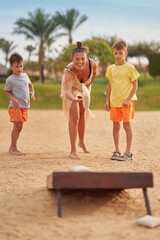 Mother with son plays bean bag game cornhole in Egypt Hurghada