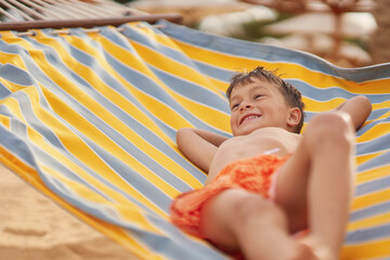Happy boy kid on hammock on the beach Hurghada Egypt