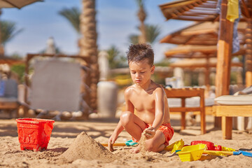 Young boy playing in sand on the beach Hurghada Egypt
