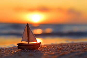 A small toy sailboat on the beach with a sunset in the background.