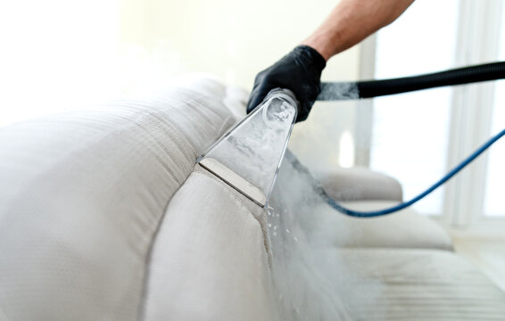 Cleaning concept. Sofa in the room. Virus prevention sanitizing inside. Process of deep furniture cleaning. Professionally chemical cleaning