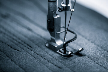 Closeup of the electric household sewing machine and item of clothing.