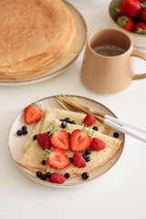 French homemade pancake crepes with strawberries. Summer breakfast. Front view