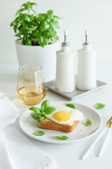 Croque madam sandwich with cheese and egg on white wooden table.