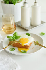 Croque madam sandwich with cheese and egg on white wooden table.