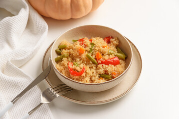 Quinoa vegetable salad on white wooden table. Vegetarian and diet food