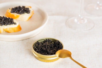 Black caviar in the gold jar with glasses of champagne and toasts on the table. Sturgeon caviar.