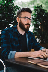 Serious man working on laptop in cafe