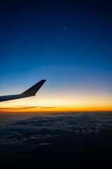 on a plane looking over the wing at sunset