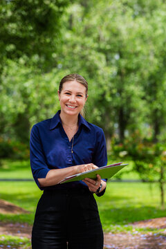 Businesswoman holding speech therapist resources outside