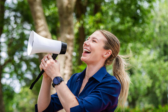 Communication concept megaphone held by speech pathologist shouting outdoors