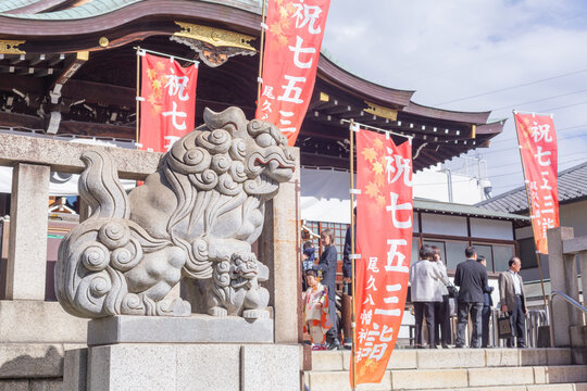 stone sculpture of lion-dog and red banners celebration shichi -go-san in front of main shrine