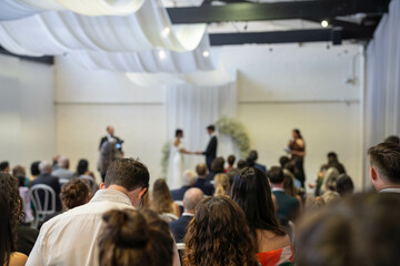Obraz premium guests watching at a wedding a ceremony celebrating with the husband and bride