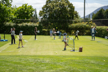 Obraz premium children playing tennis on grass, kids playing lawn tennis in australia as a family