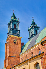 Obraz premium Bell towers and spires and religious cross on the Archcathedral Basilica of St. Peter and St. Paul in Poznan, Europe, Poland