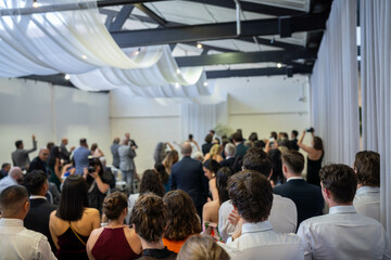 guests watching at a wedding a ceremony celebrating with the husband and bride