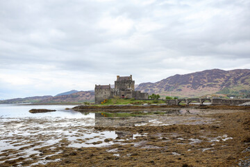 Historic castle by the sea in Scotland, surrounded by rugged landscape and low tide, offering a glimpse into the region's rich heritage and natural beauty