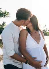 Fototapeta premium Romantic pregnant couple kissing on seashore