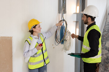 team electrical engineers or technicians is professionally inspecting the wiring and systems in the building. Check electrical equipment to meet safety standards. Use a tablet to check buildings.