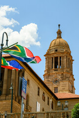 The South African flag with the Union Buildings in the background