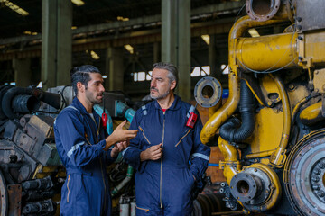 Technicians work at train engine repair shop.