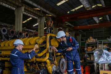 Technicians work at train engine repair shop.