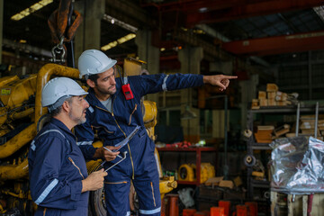 Technicians work at train engine repair shop.