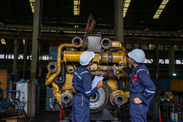 Technicians work at train engine repair shop.