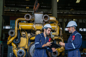 Technicians work at train engine repair shop.