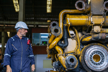 Technicians work at train engine repair shop.