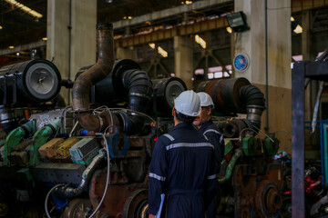 Technicians work at train engine repair shop.