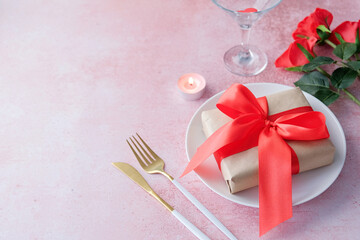 valentines day background. table setting with roses, candle, plate with gift box ad glass, copy space