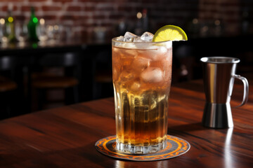 Iced tea with lemon wedge garnish in a tall glass on a bar counter.