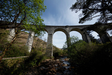 Exploring the Glenfinnan Viaduct in Scotland, a historical landmark surrounded by lush nature and tranquil waters
