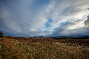 Majestic clouds over the rugged landscape of Isle of Skye in Scotland during a crisp afternoon