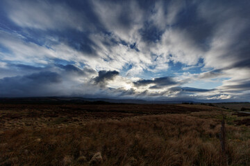 Dramatic cloud formations over the rugged landscape of Isle of Skye in Scotland during an overcast day