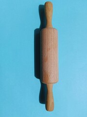 Rolling pin on blue background 