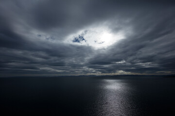 Fototapeta premium Dramatic clouds over the sea at Isle of Skye, Scotland, highlighting nature's power and beauty during twilight hours