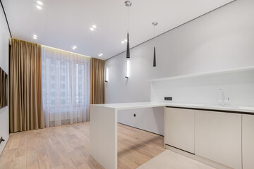Magnificent design of the studio apartment with a large window and an installed kitchen set. White wall decor, light beige laminate.