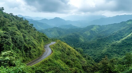 A winding road through lush green mountains under a cloudy sky.