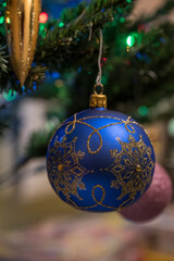 Christmas ornament in the shape of a blue ball with gold glitter.
