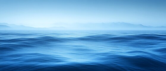 Obraz premium Misty ocean waves and distant mountains.