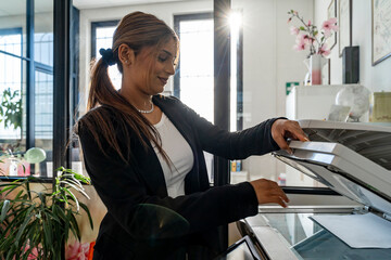 elegant business woman activating laser printer to scan a document in a modern office